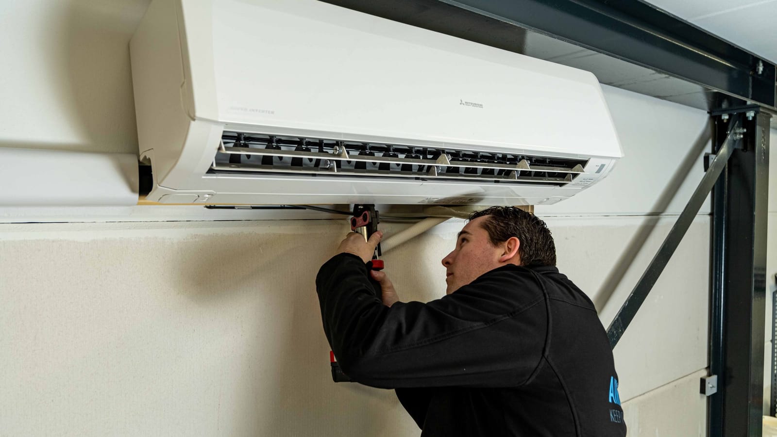 Monteur van KlimaatCREW installeert een airconditioning binnenunit